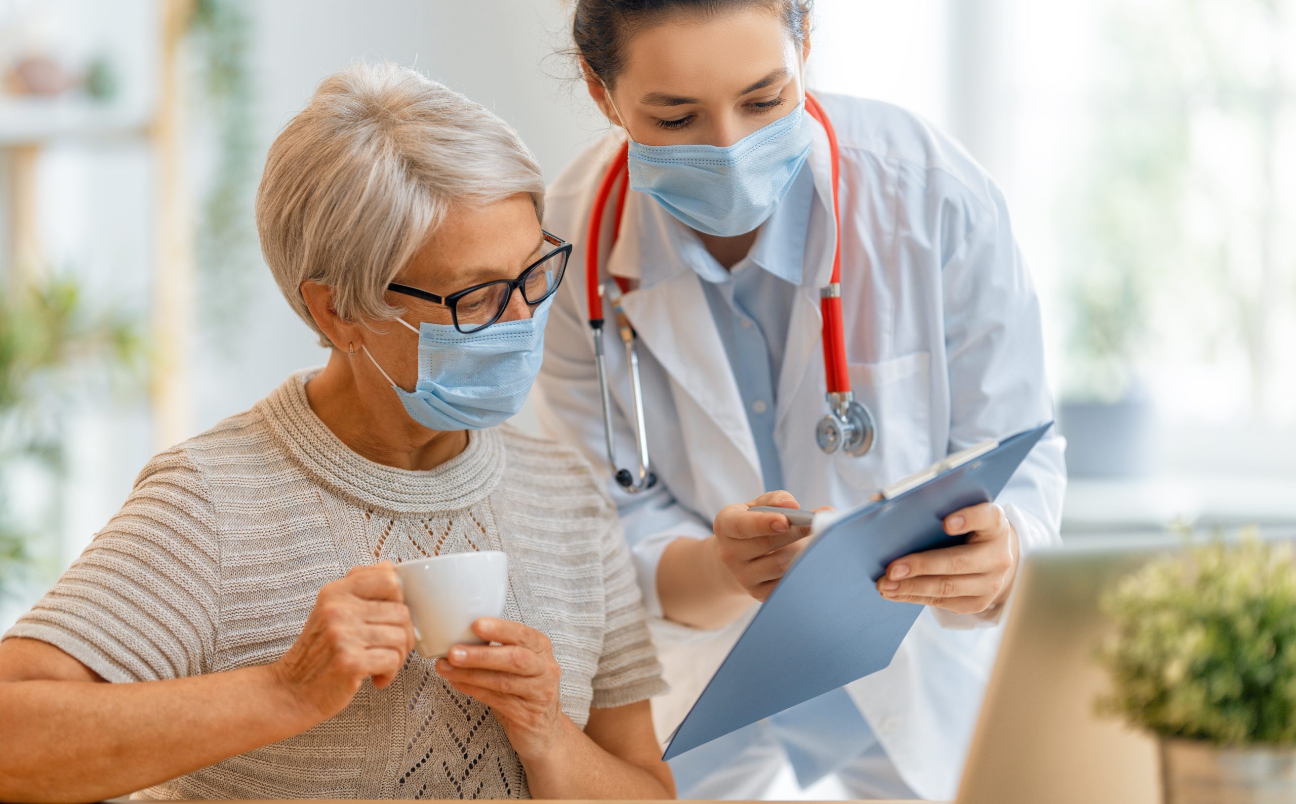 Doctor and senior woman wearing facemasks during coronavirus and flu outbreak. Virus protection. COVID-2019. Taking on masks.