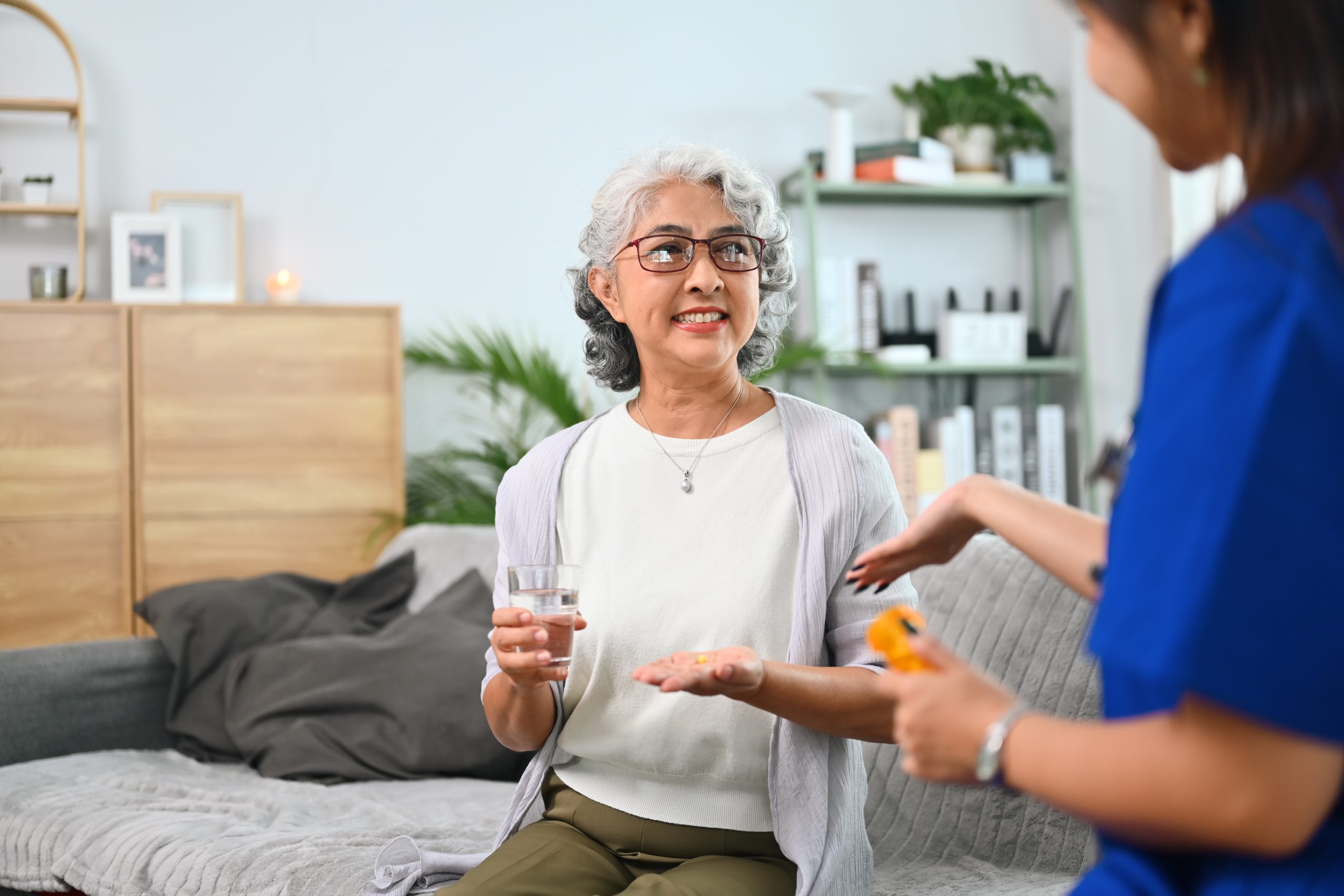 Health visitor explaining medicine dosage to mature woman. Home health care service concept.